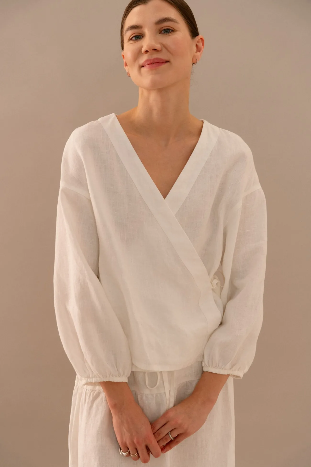 Milky white linen wrap blouse with relaxed fit, styled with high-waisted tiered linen skirt