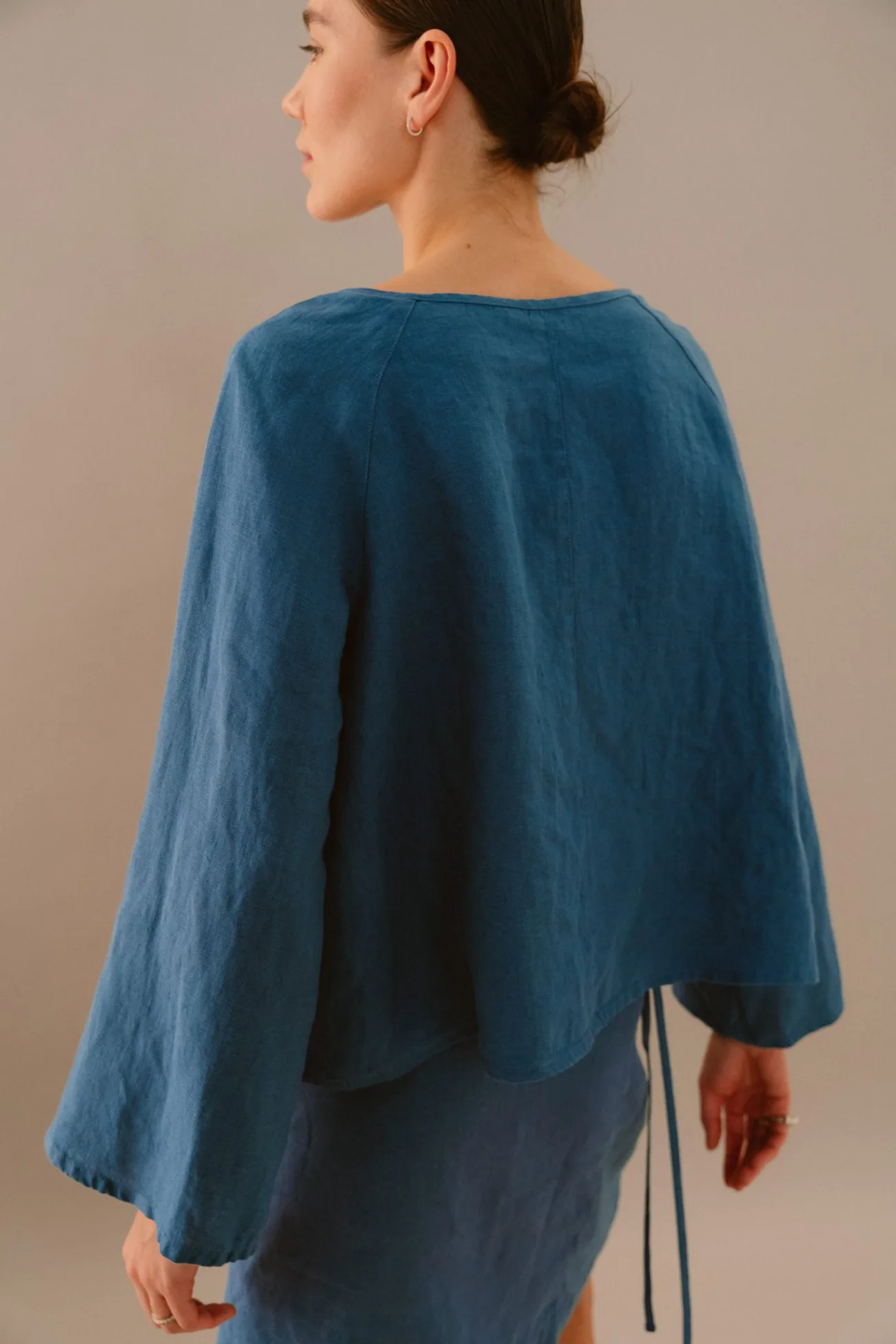 Back view of stellar blue linen blouse with wide long sleeves and relaxed fit