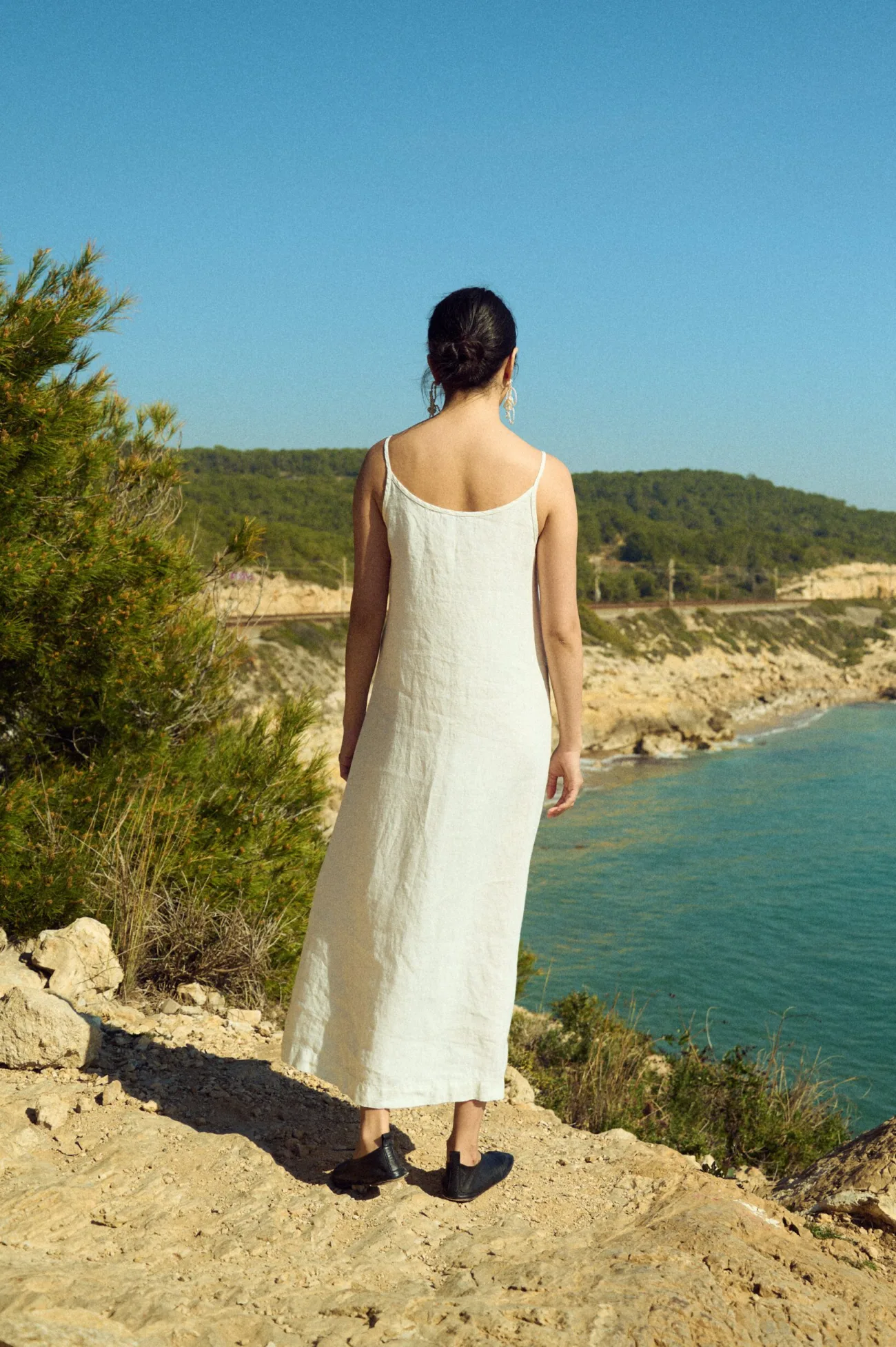 The back of the minimalist white linen slip dress with thin straps for summer