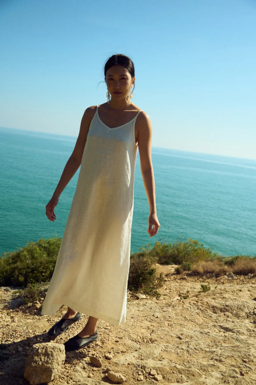 White linen slip dress with thin straps and relaxed fit styled for summer wear