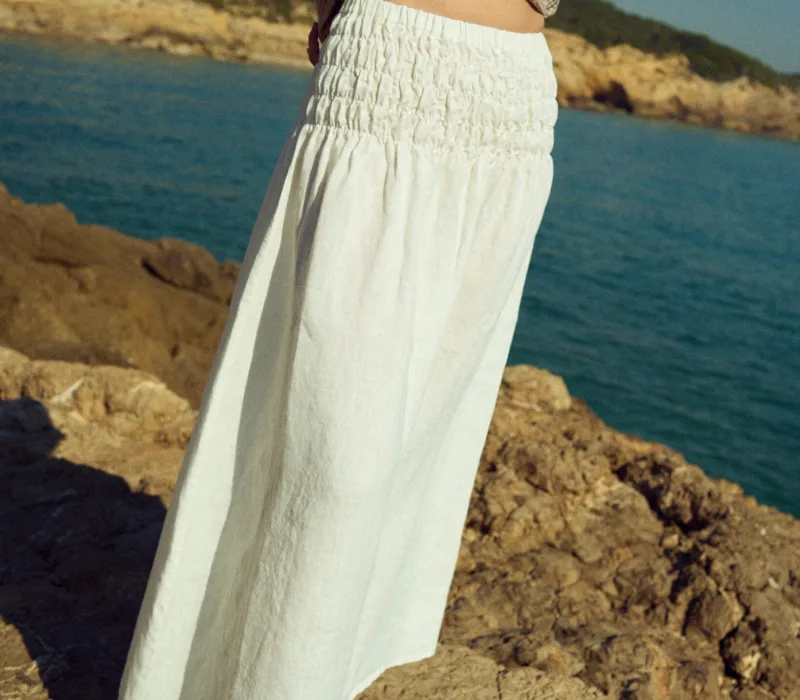 Milky white linen maxi skirt with a wide smocked elastic waistband and relaxed, flowing silhouette