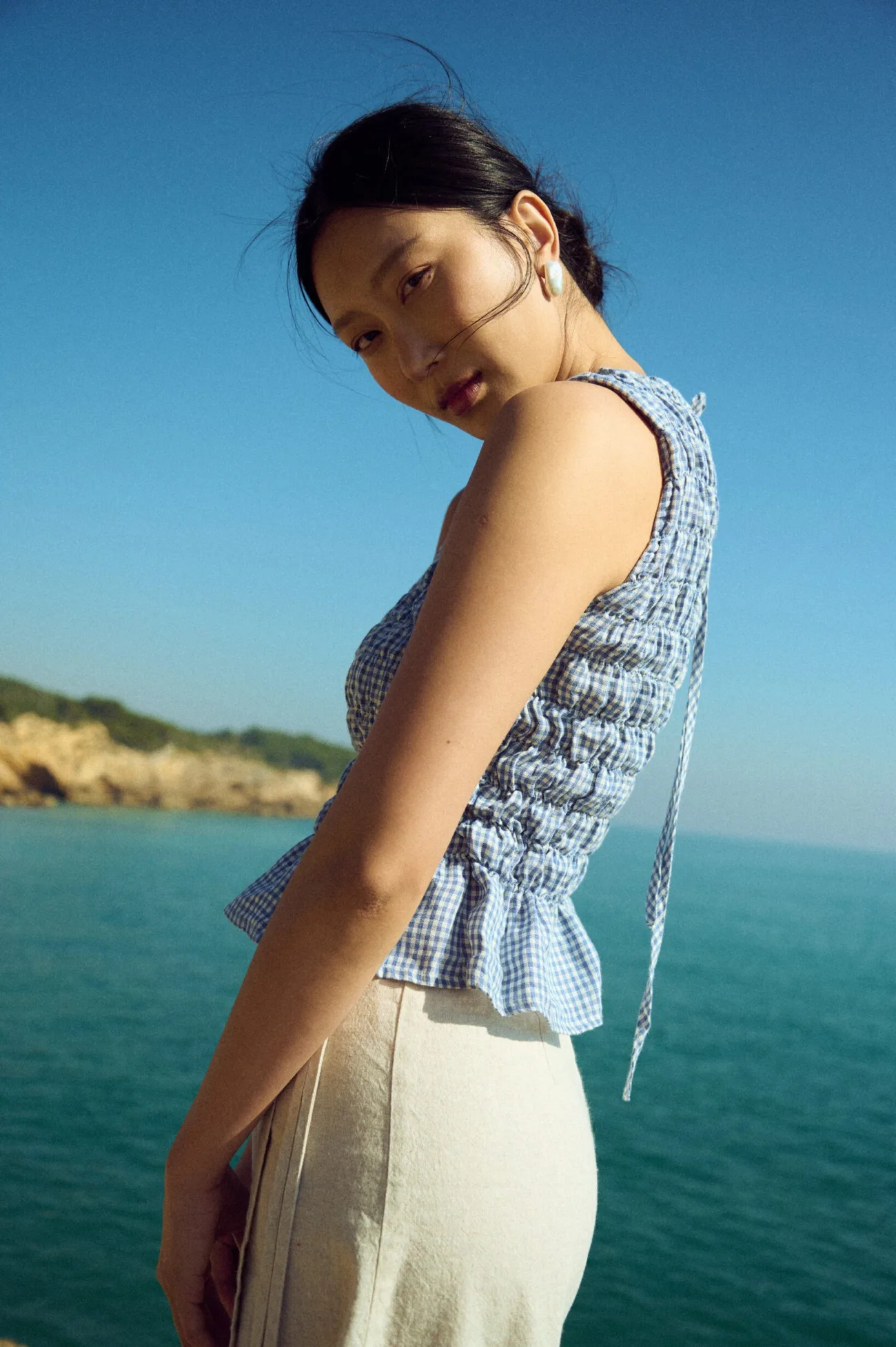Sleeveless blue gingham linen top with all-over smocking and subtle flared hem