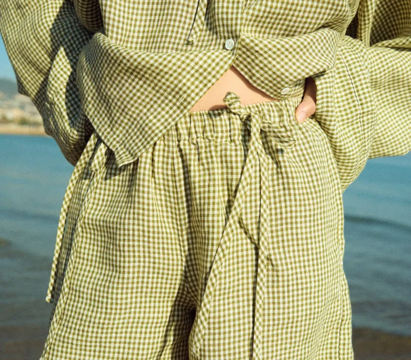 Green mini gingham linen shorts with elasticated waistband and decorative ties, paired with a matching top