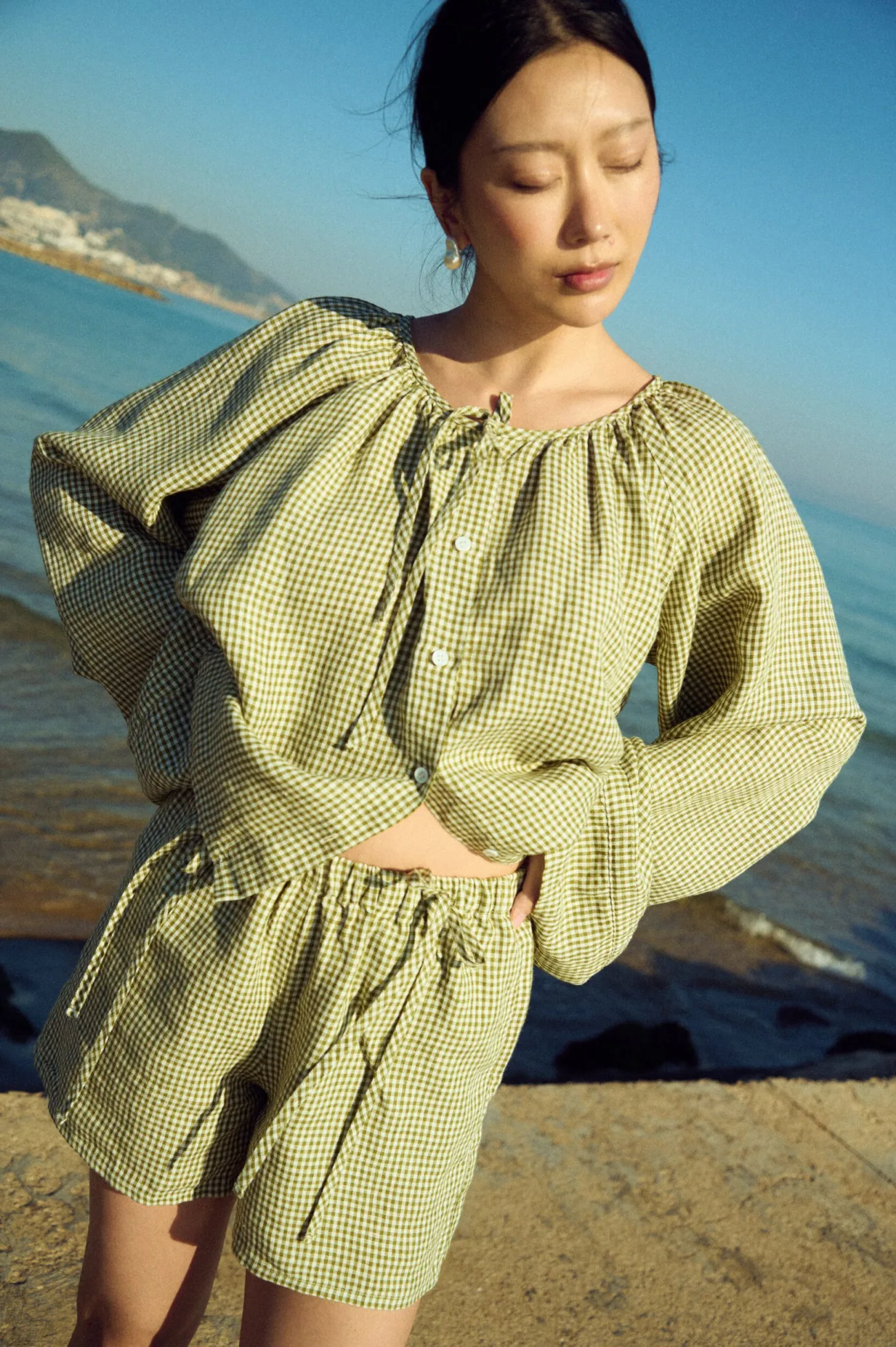 Lightweight green gingham linen top with button front and voluminous sleeves, paired with matching shorts
