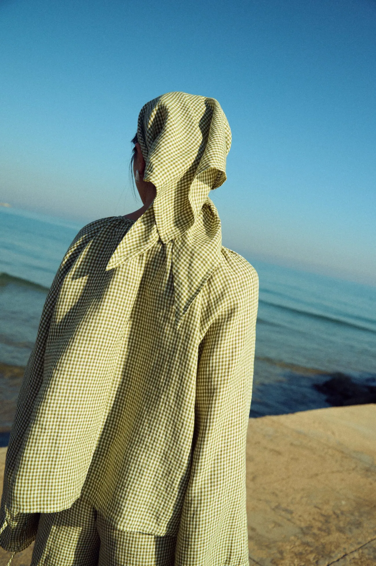 Green gingham linen set with relaxed top, wide sleeves and matching shorts, styled with a coordinating headscarf