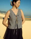 Black gingham linen blouse with adjustable tie closure worn with a black linen mini skirt