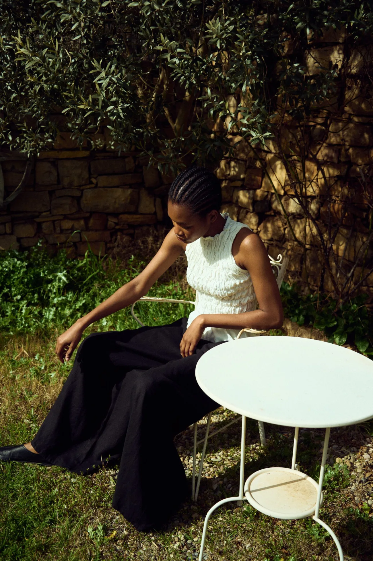 woman wearing black linen culottes and white smocked linen tank top