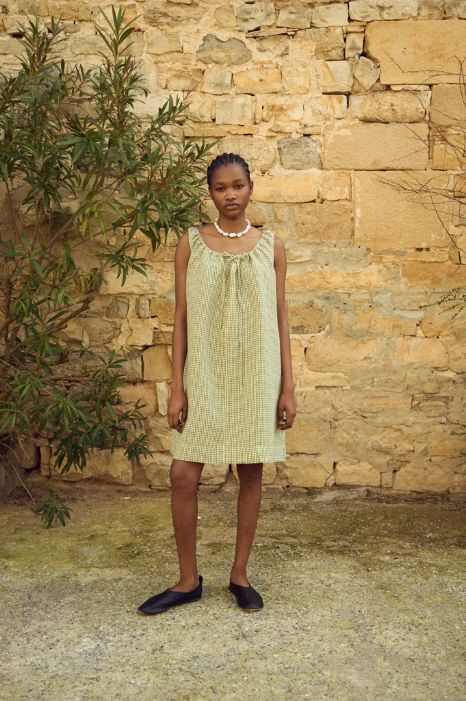 Sleeveless green gingham linen mini dress with soft gathering at the neckline and loose silhouette