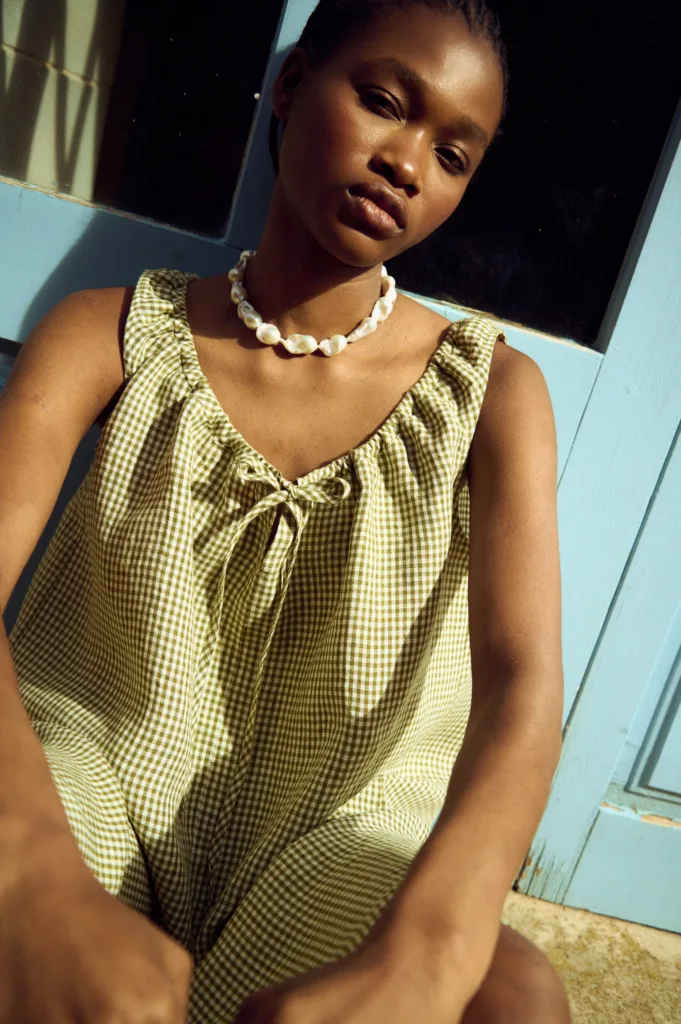 Close-up of green gingham linen dress with gathered neckline and tie-front detail