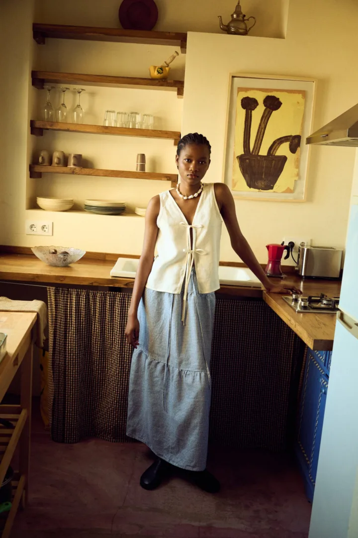 woman wearing white linen tie front top and mini gingham linen skirt