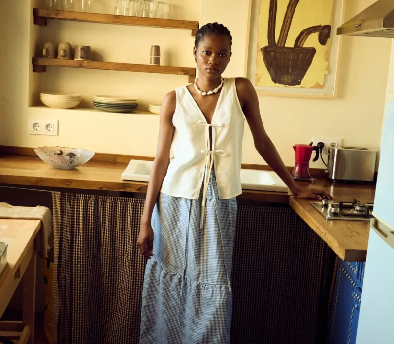 woman wearing white linen tie front top and mini gingham linen skirt