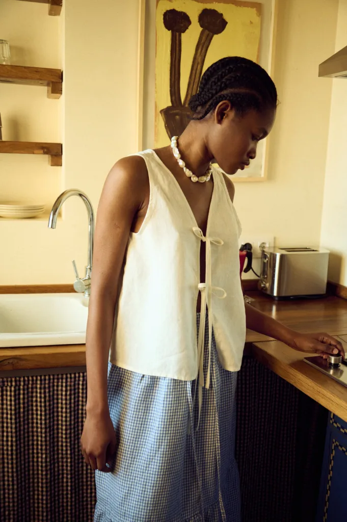 close up view of white linen tie front top and gingham linen skirt