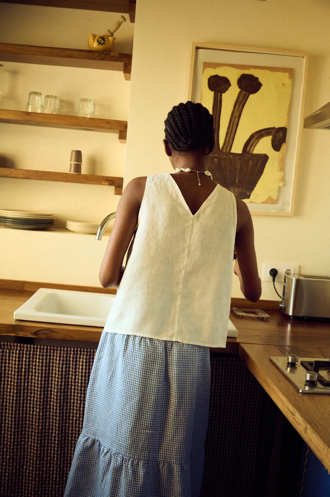 the back view of white linen tie front top and tiered gingham linen skirt