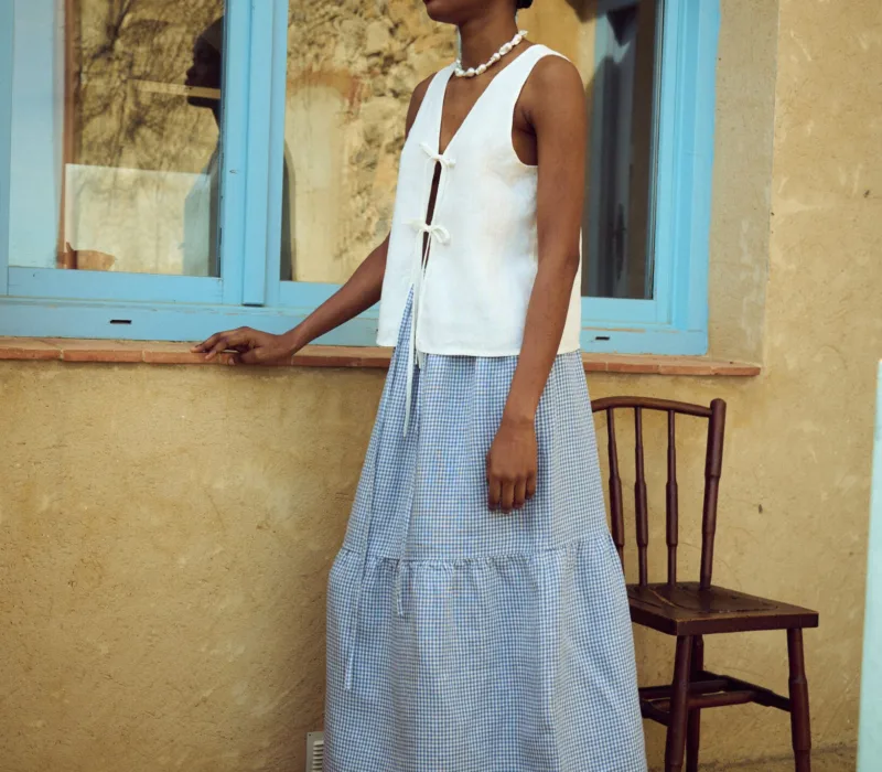 Blue gingham linen skirt with a gathered tier and soft volume, paired with a white linen top
