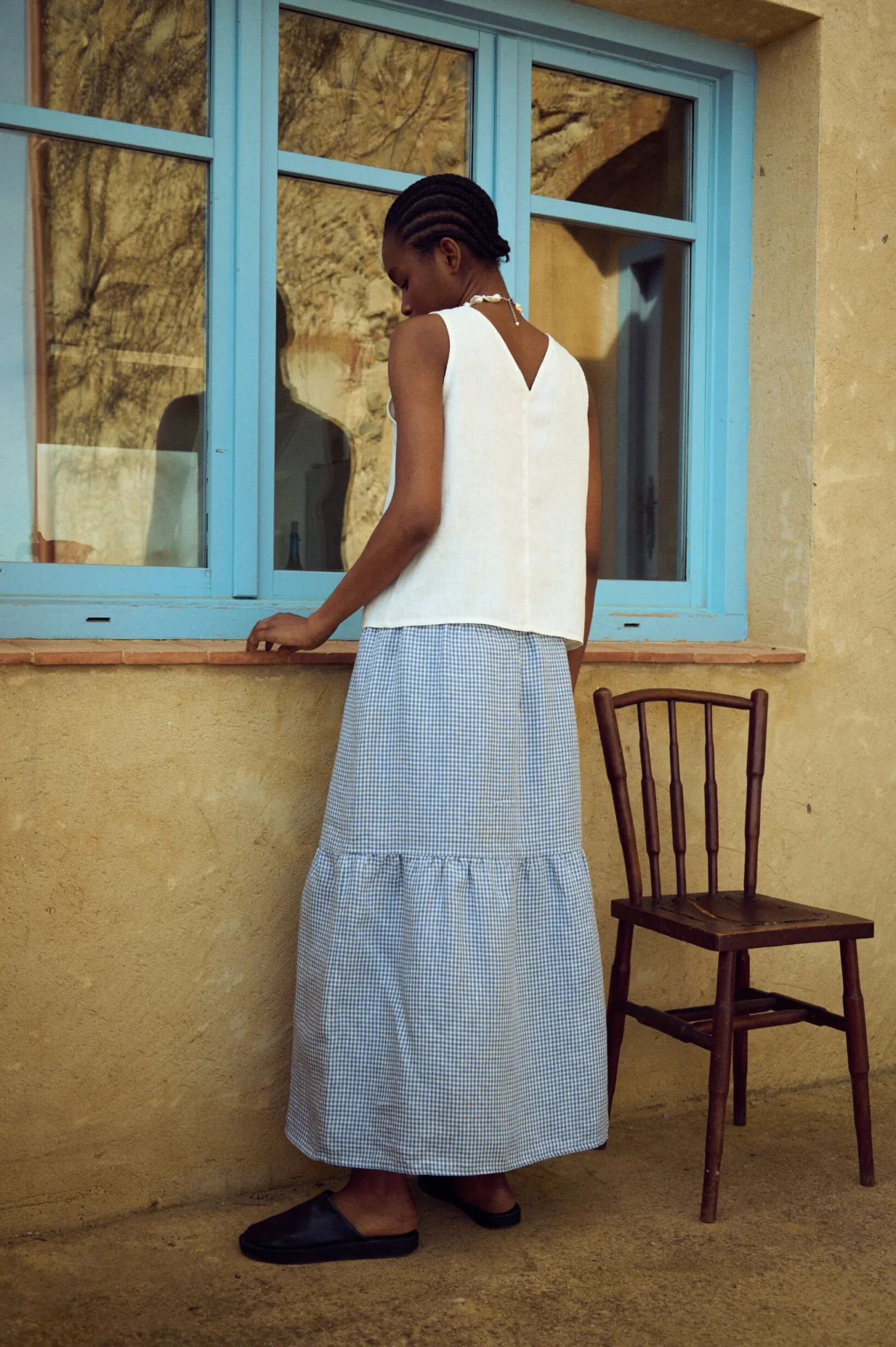 Tiered blue gingham linen skirt with gentle volume and fluid movement, styled with a white linen top