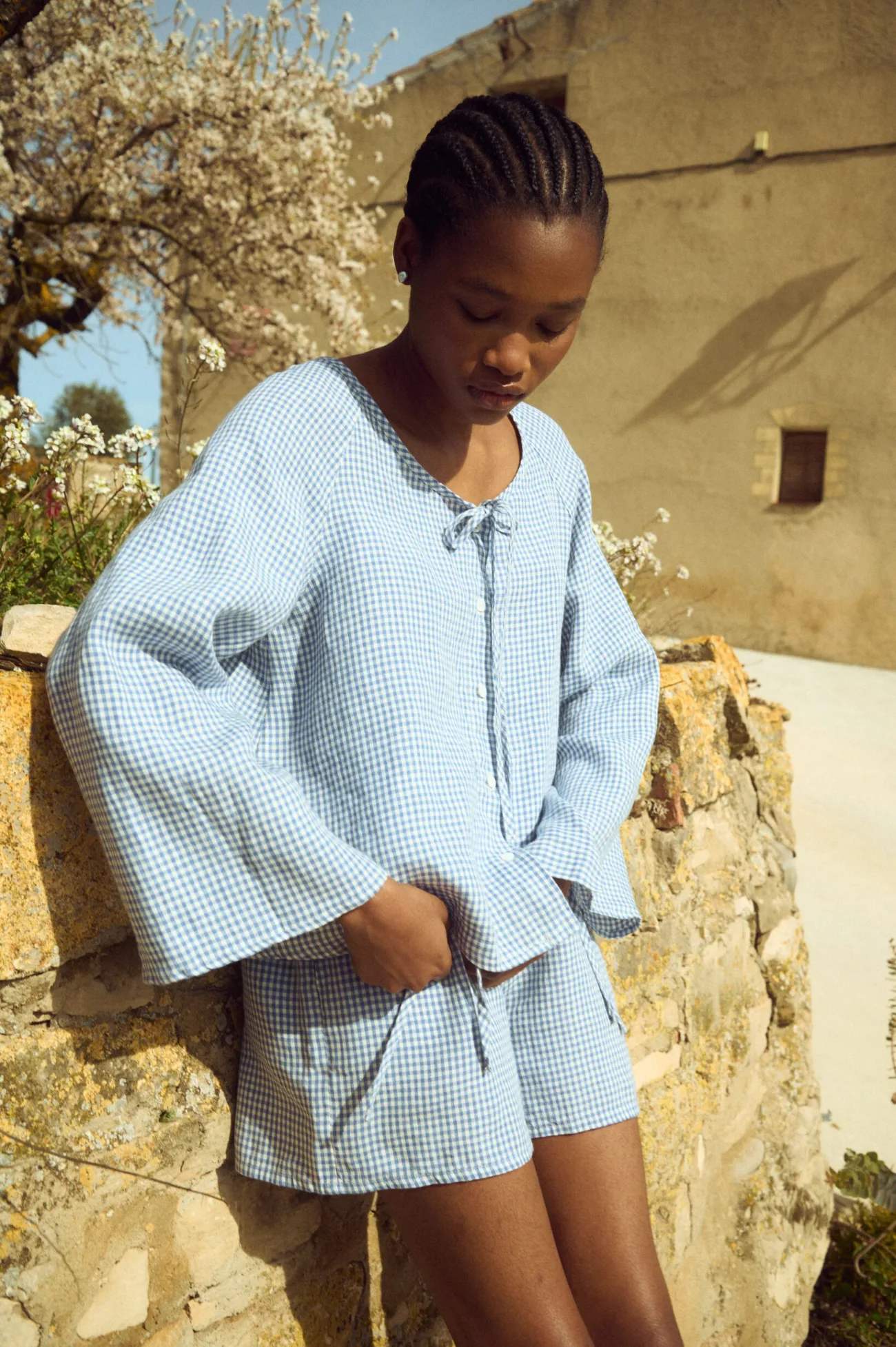 Lightweight blue gingham linen top with relaxed fit and wide bell sleeves, paired with matching linen shorts
