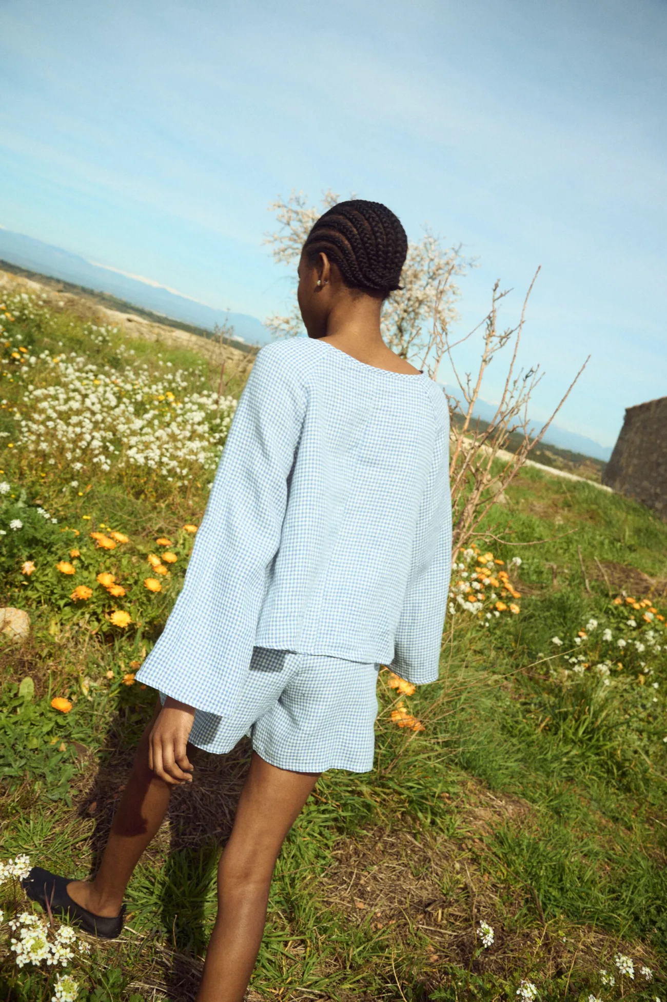 Blue mini gingham linen blouse with easy silhouette and airy sleeves, shown from the back