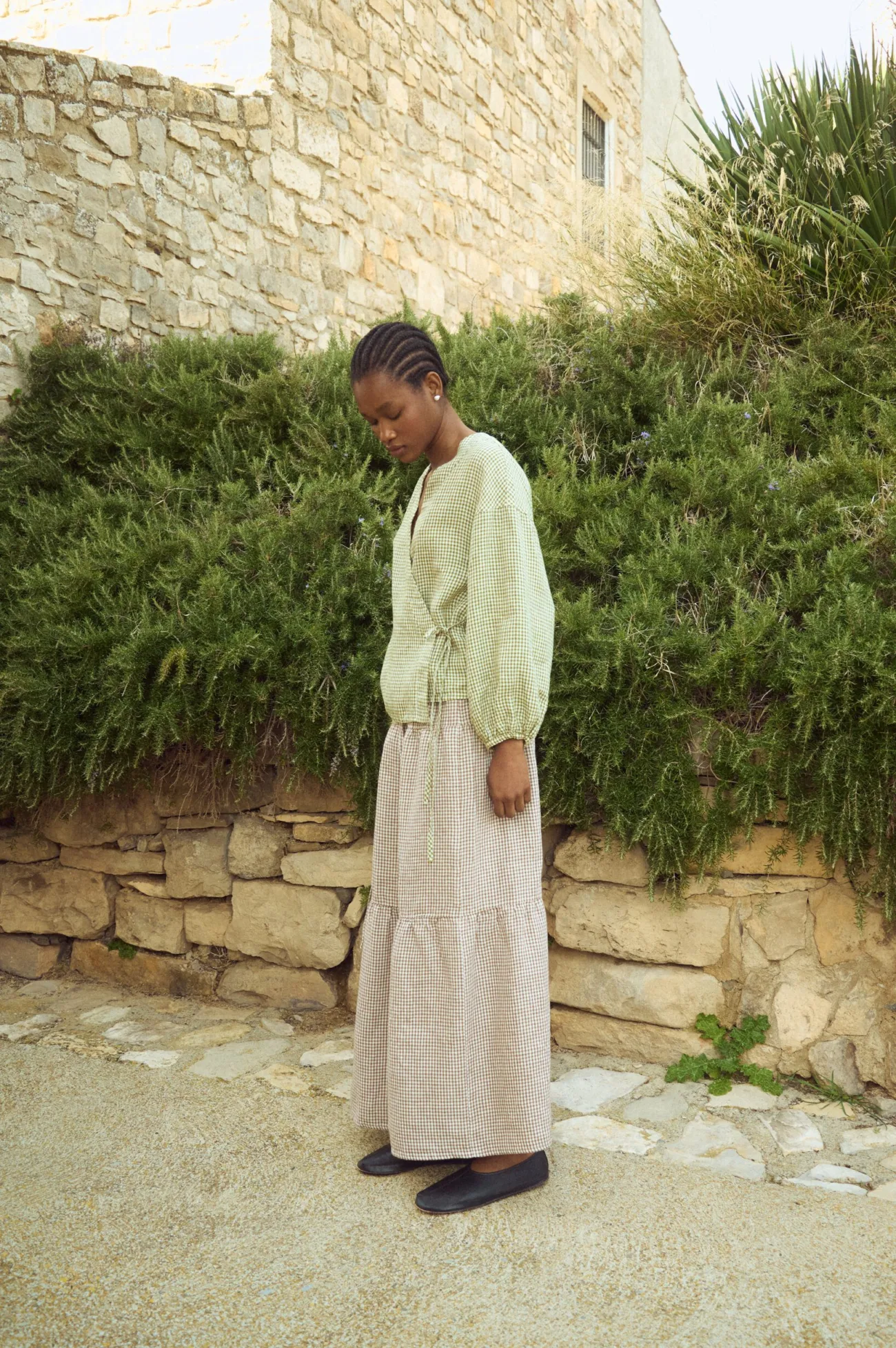 Tiered brown gingham linen maxi skirt with soft volume and airy movement, paired with a relaxed wrap-style linen top