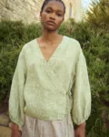 Green mini gingham linen wrap top with soft V neckline and adjustable side tie, paired with a brown gingham linen skirt