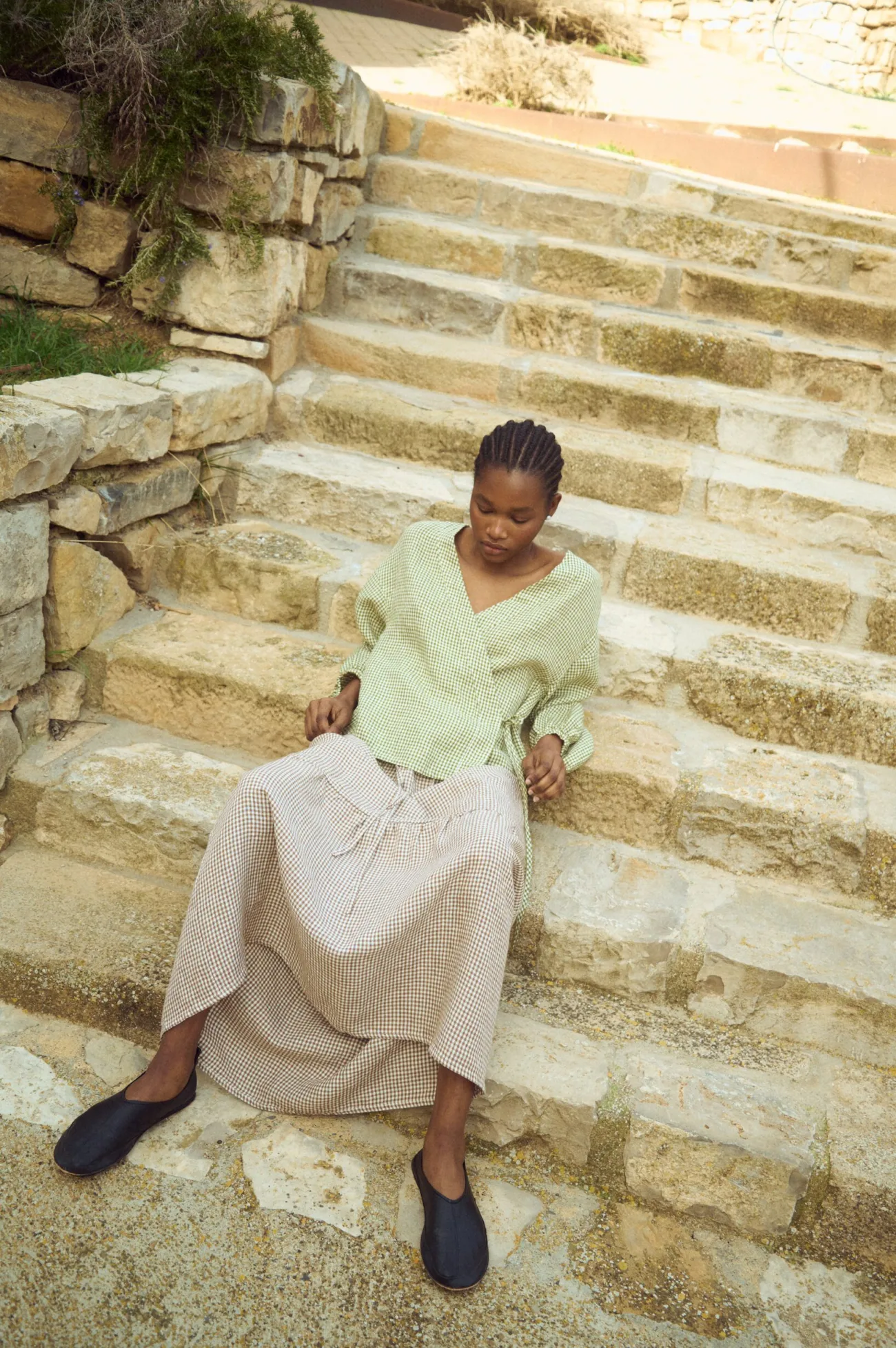 Tiered brown gingham linen skirt with soft volume and airy movement, paired with a relaxed wrap-style linen top