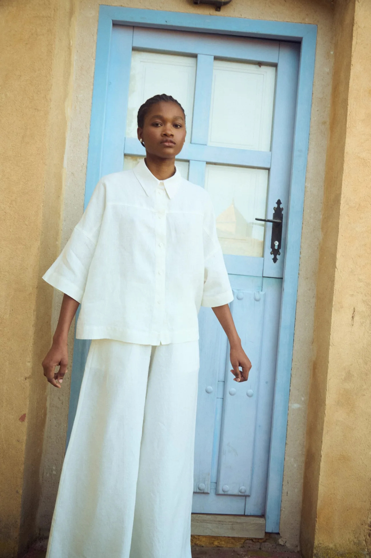 woman wearing the set of white linen culottes and matching linen shirt