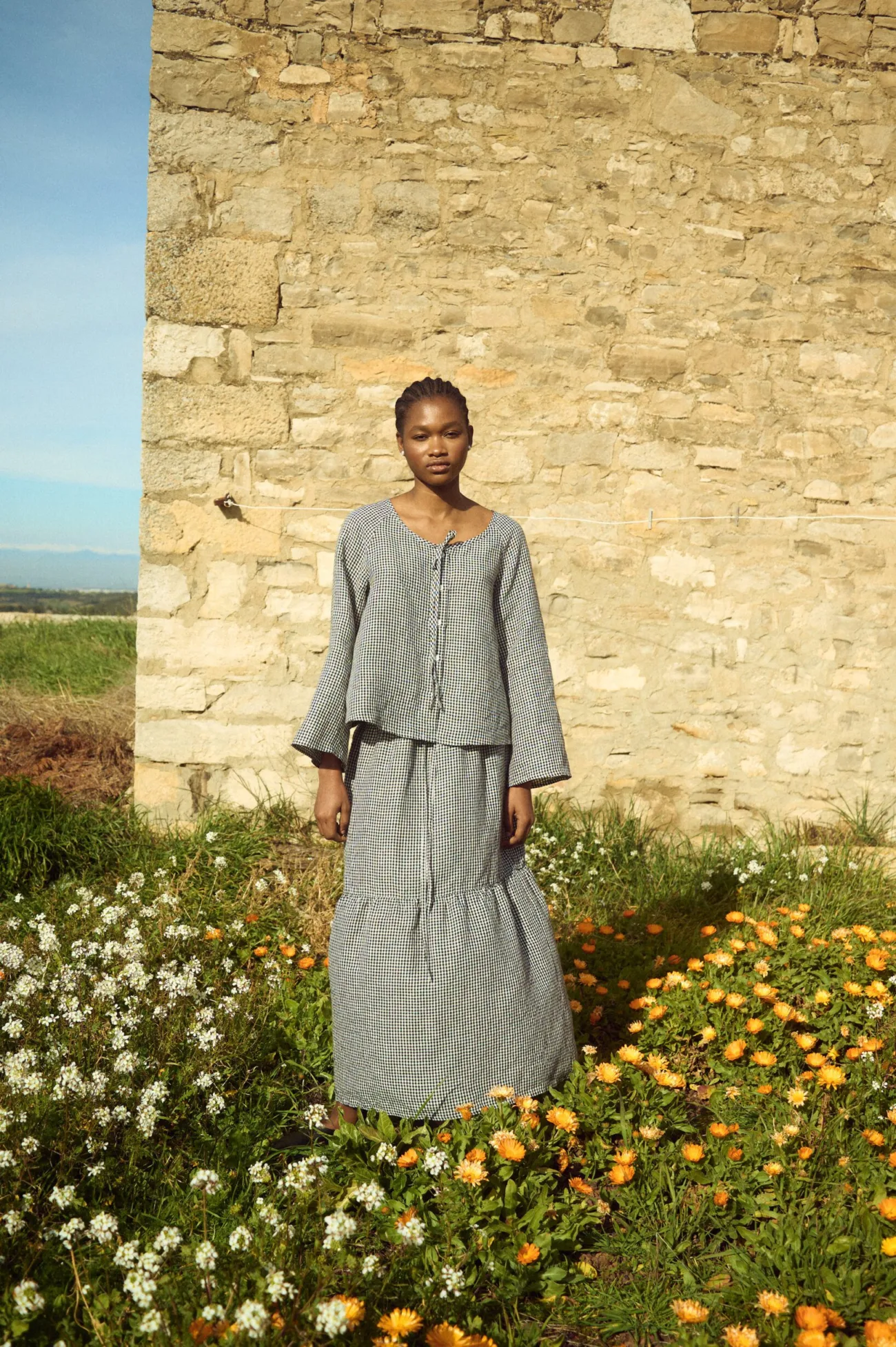 Black gingham linen top with gathered neckline and subtle volume through the sleeves, paired with a matching maxi linen skirt