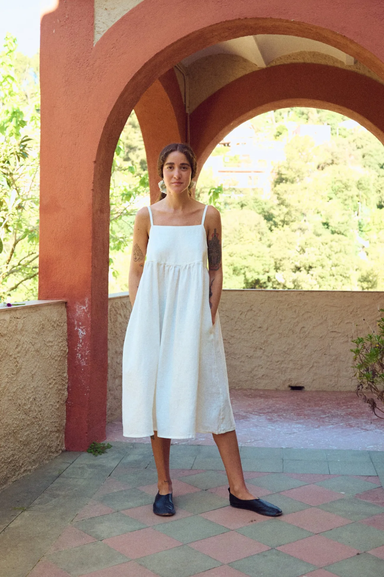 woman wearing spaghetti straps midi dress with pockets in white linen