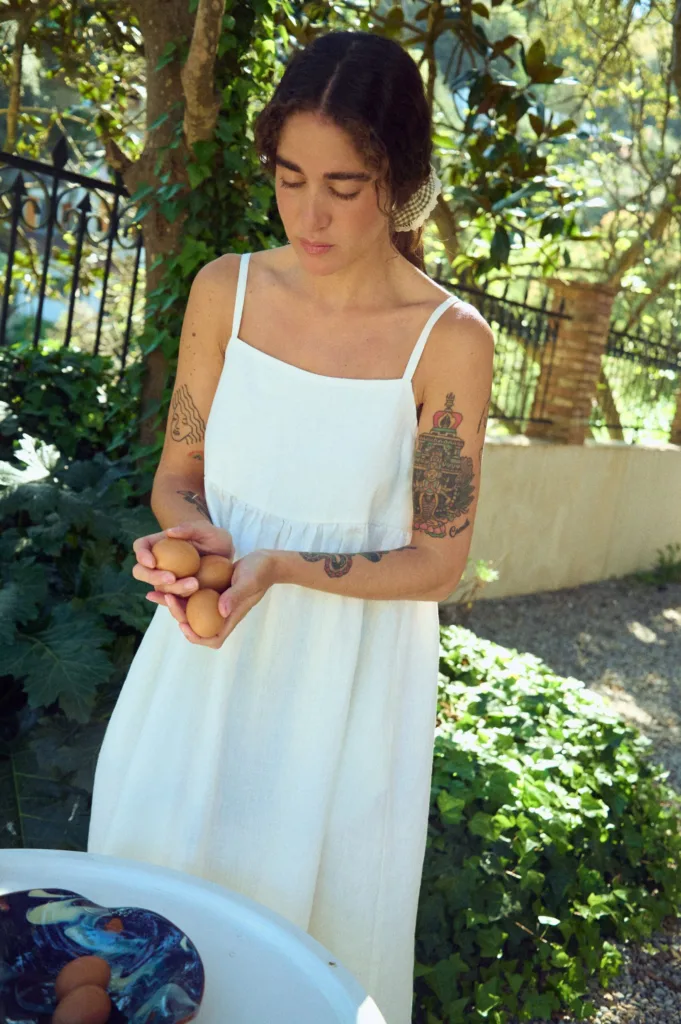 woman wearing white summer pinafore dress with spaghetti straps