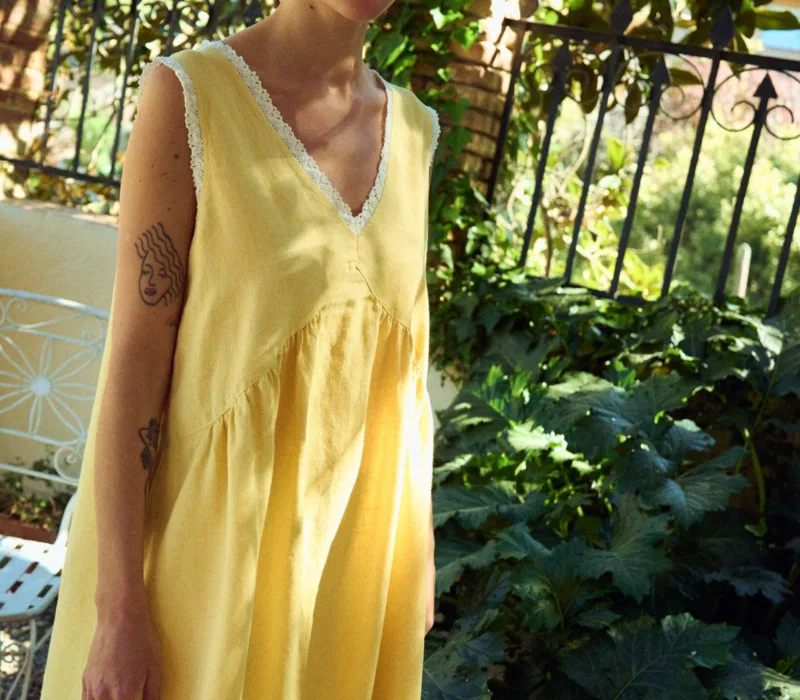 Butter yellow linen sleeveless midi dress with lace-trim V-neck, armholes, and hem, and a gently gathered waist