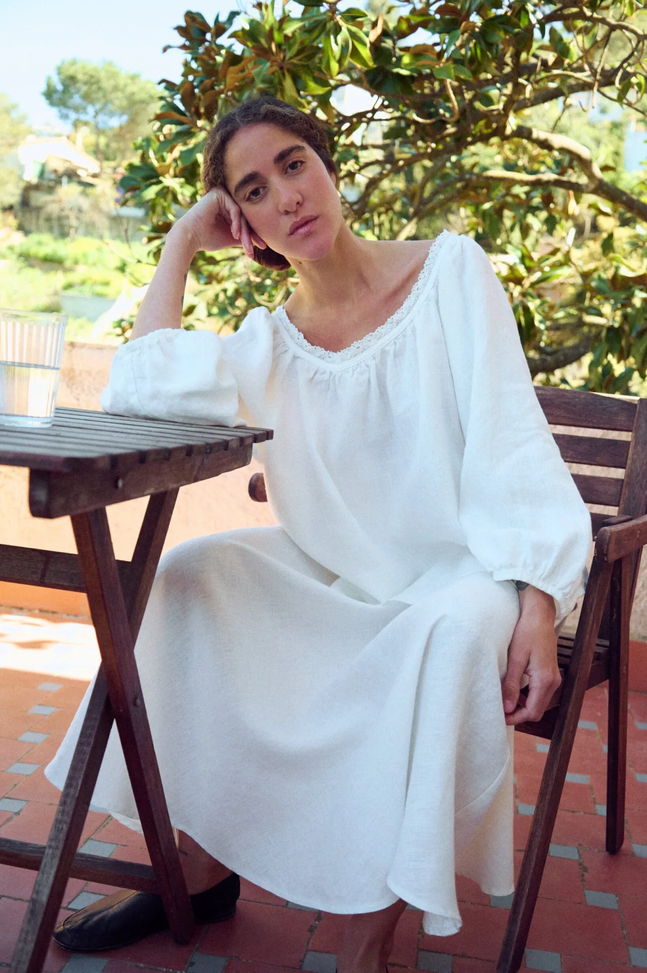 Milky white linen blouse with lace-trim scoop neckline and billowy sleeves, paired with a softly draped skirt