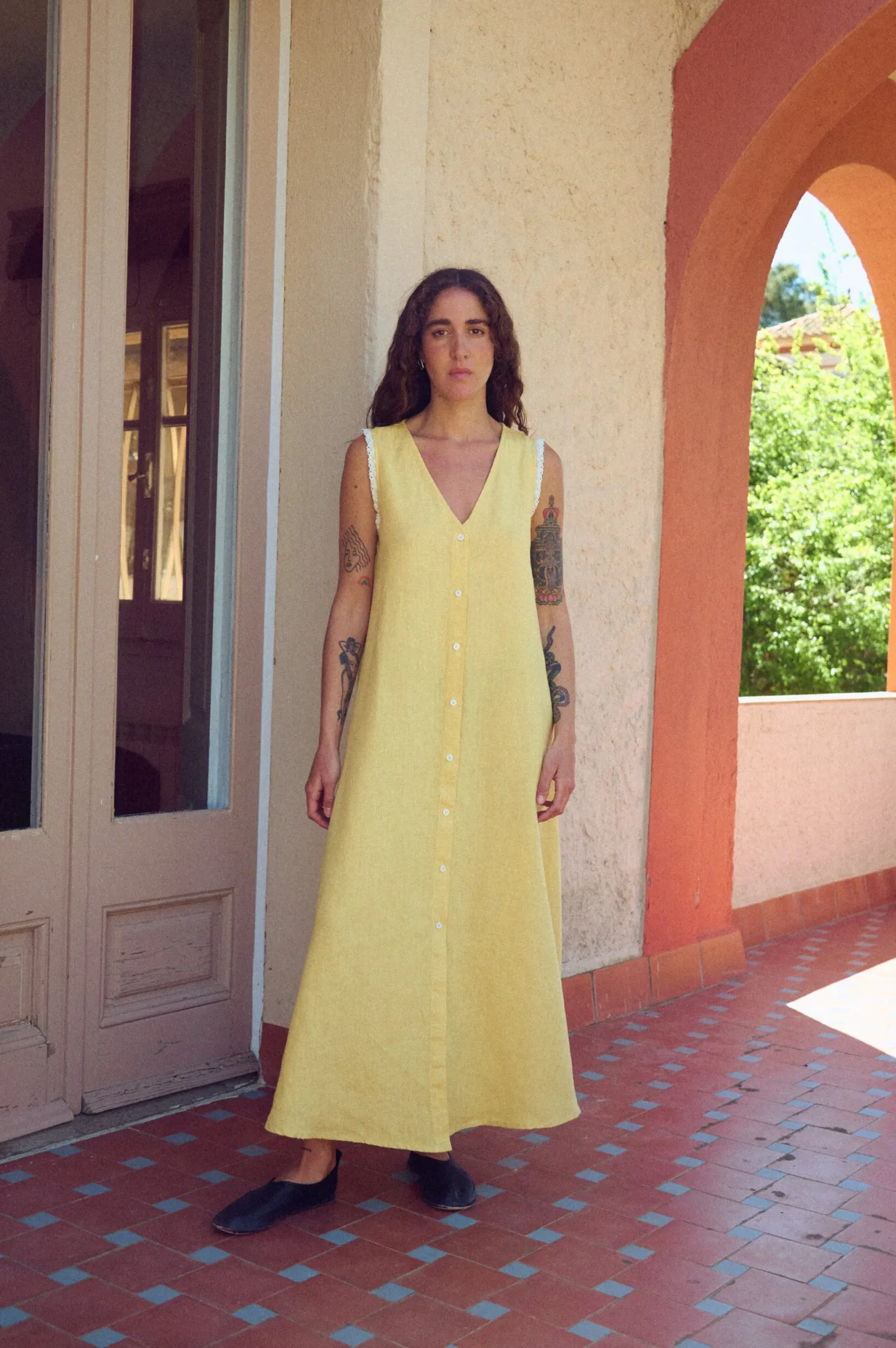 Front view of butter yellow linen sleeveless maxi dress with button-down front, V-neck, lace trim, and relaxed A-line silhouette