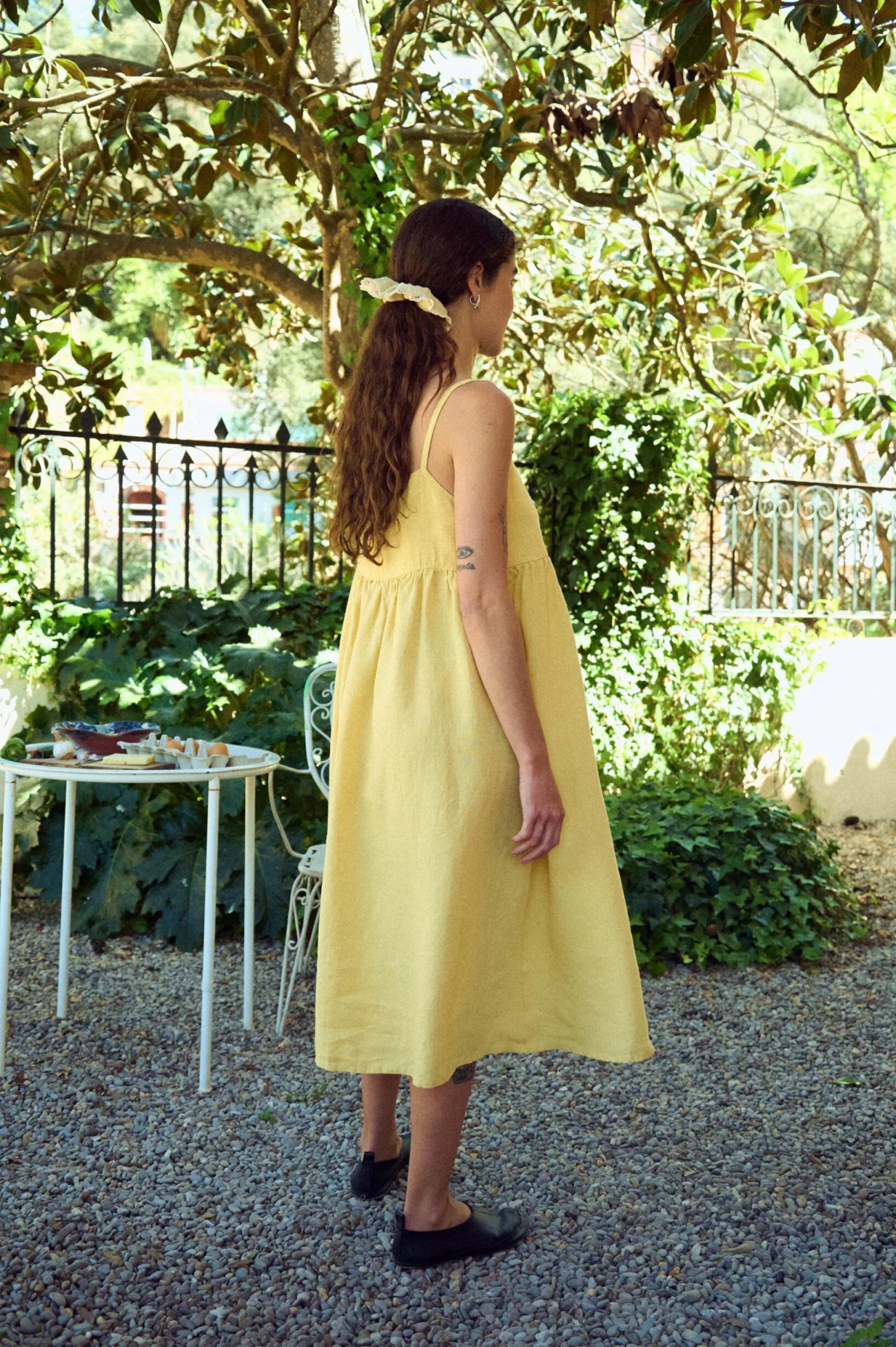back view of spaghetti straps butter yellow dress in midi length