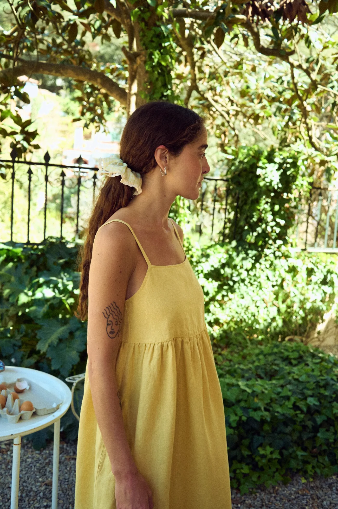 side view of midi length summer pinafore yellow linen dress with straps