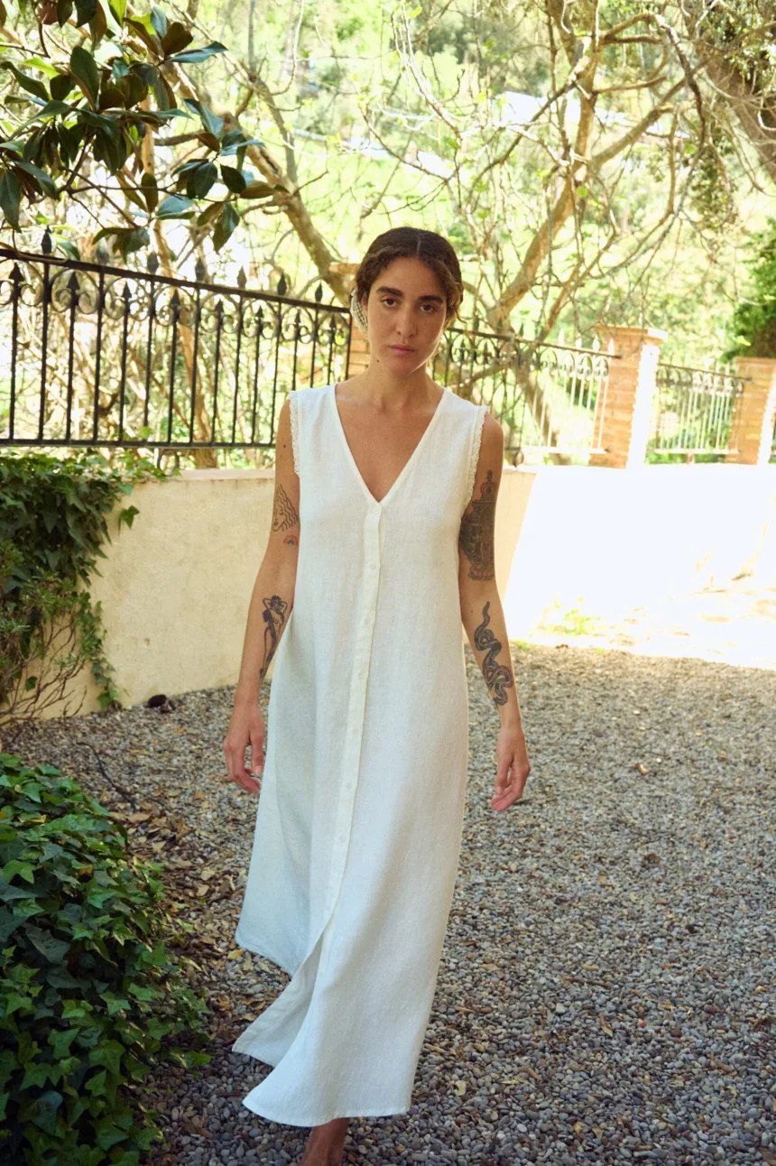 Front view of milky white linen sleeveless maxi dress with button front, V-neck, lace-trimmed armholes, and easy flowing fit