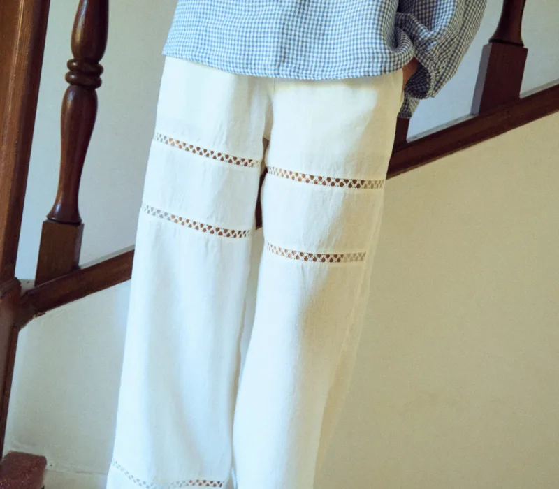 woman is wearing white lace pants in white linen