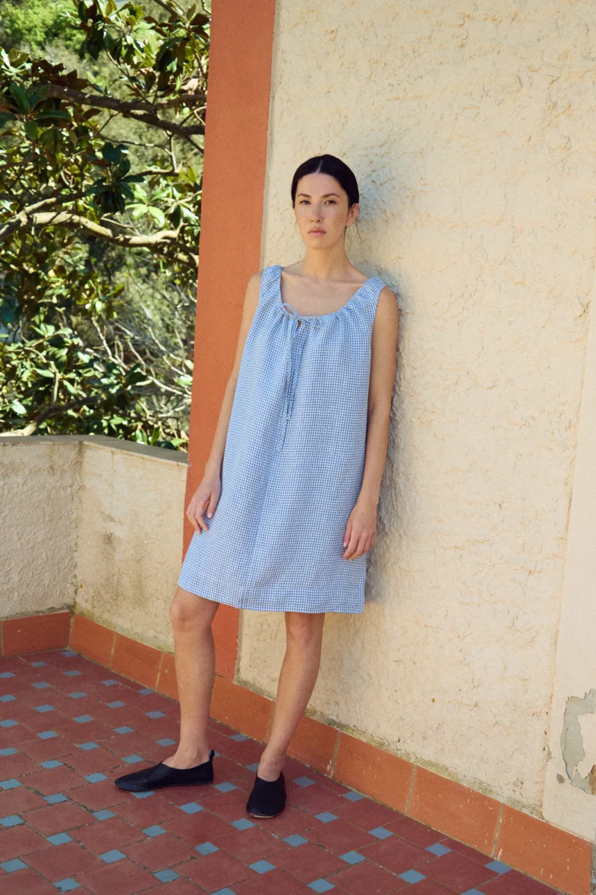 full view of mini length blue gingham dress with oversized fit and drawstring neckline
