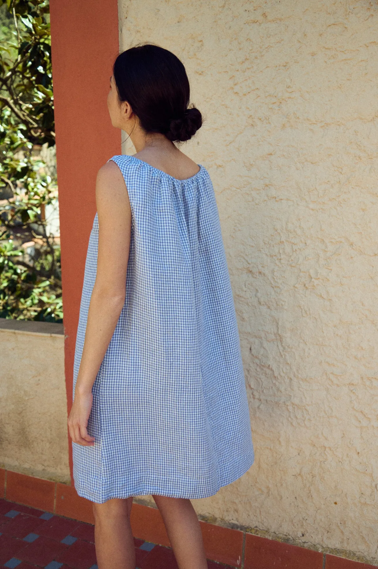 back view of loose fit mini dress in blue gingham linen