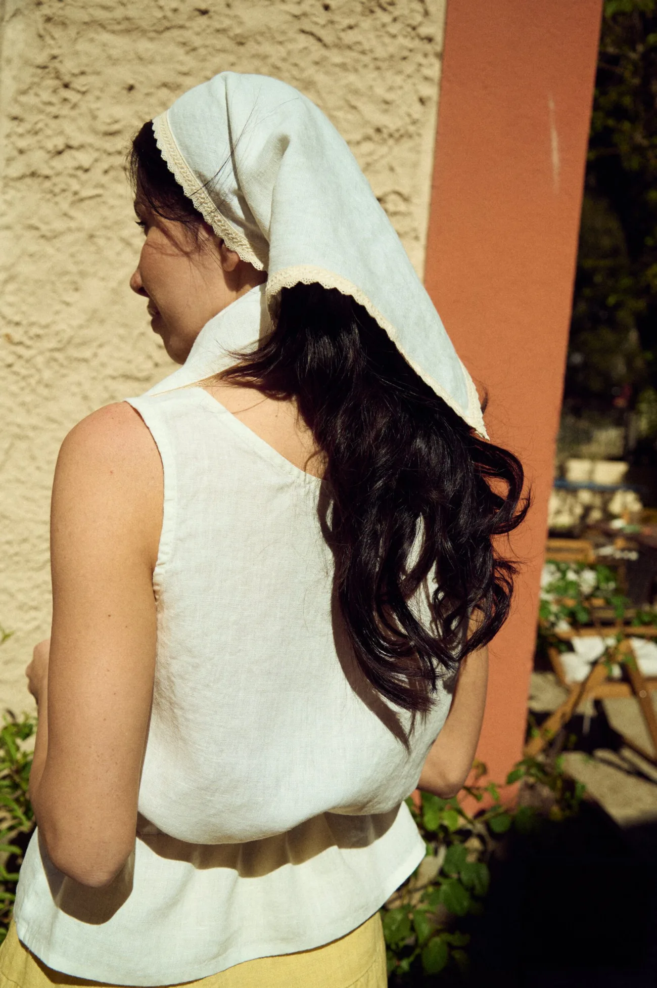 back view of woman wearing triangle white lace linen bandana