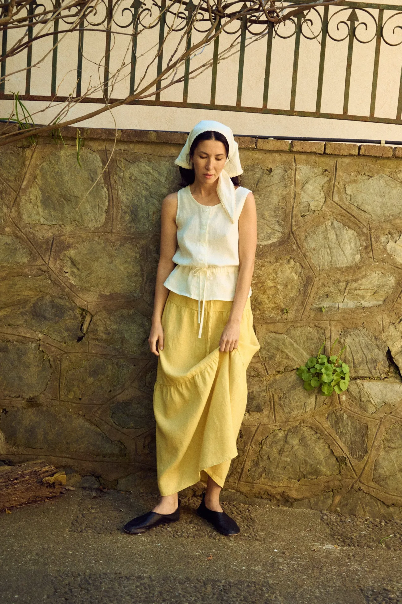 woman wearing tiered butter yellow linen skirt and white linen top