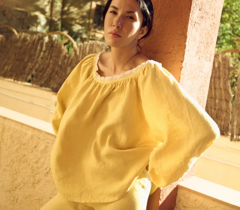 woman is wearing oversized linen blouse in butter yellow color
