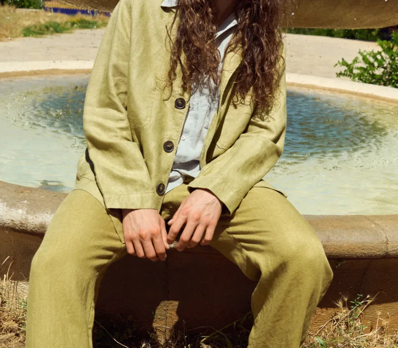 Men’s olive heavy linen jacket with a relaxed blazer-inspired silhouette, notched lapels, three-button front and roomy patch pockets, styled with matching olive linen trousers and a light grey linen shirt underneath