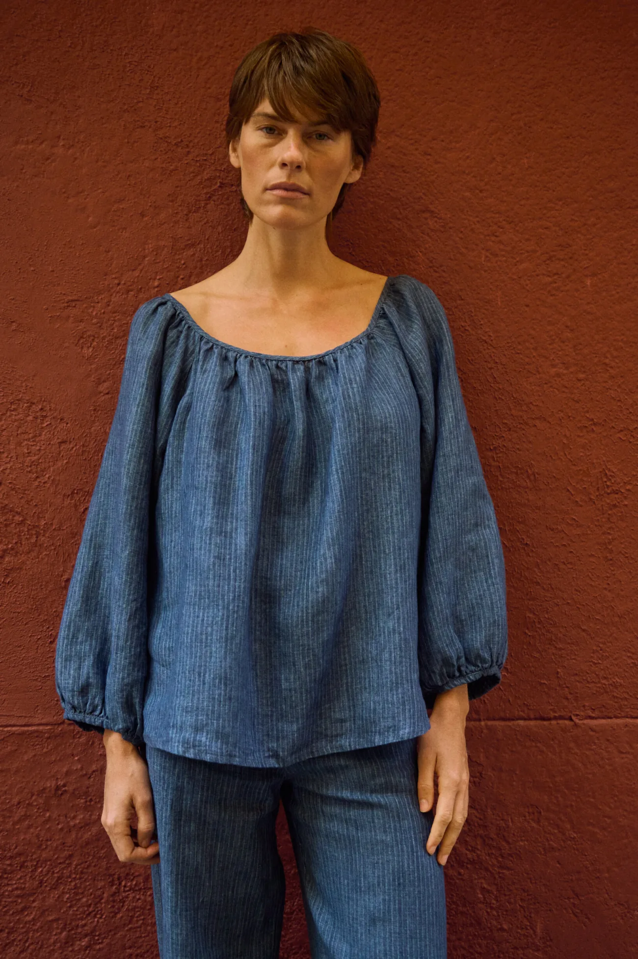 Blue striped linen blouse with a gathered scoop neckline and relaxed voluminous sleeves