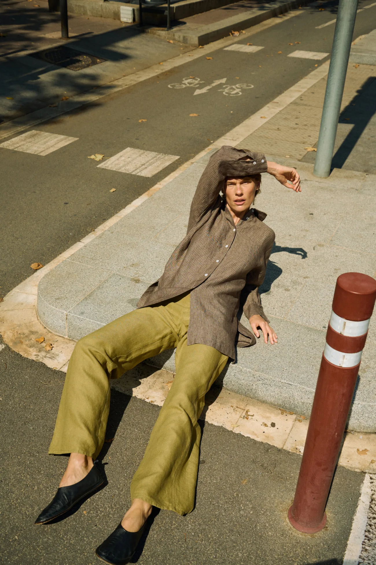 Olive heavy linen wide-leg trousers styled with a brown striped linen button-up shirt