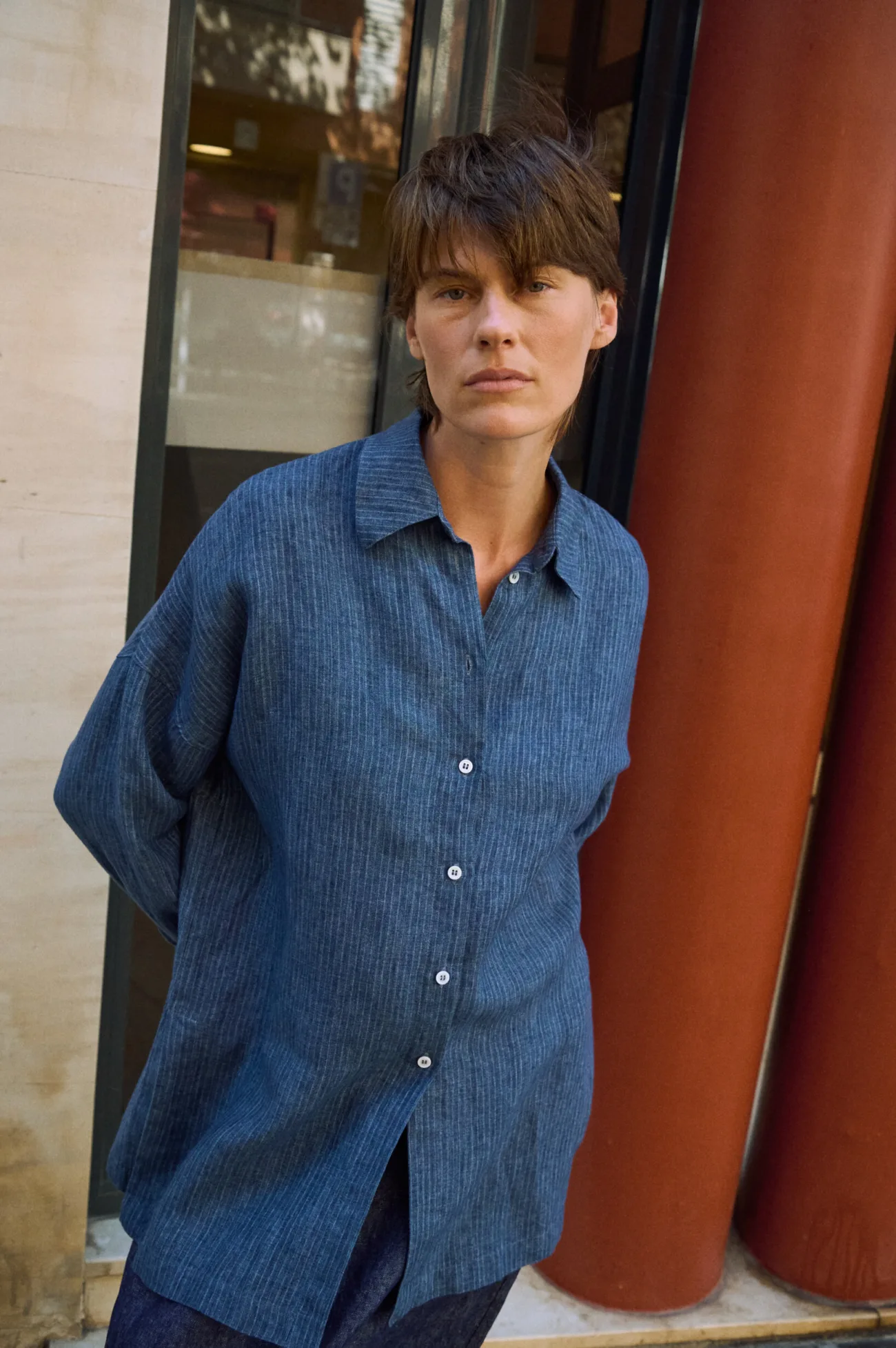 Blue striped linen button-up shirt with a relaxed oversized fit, long hem and pointed collar
