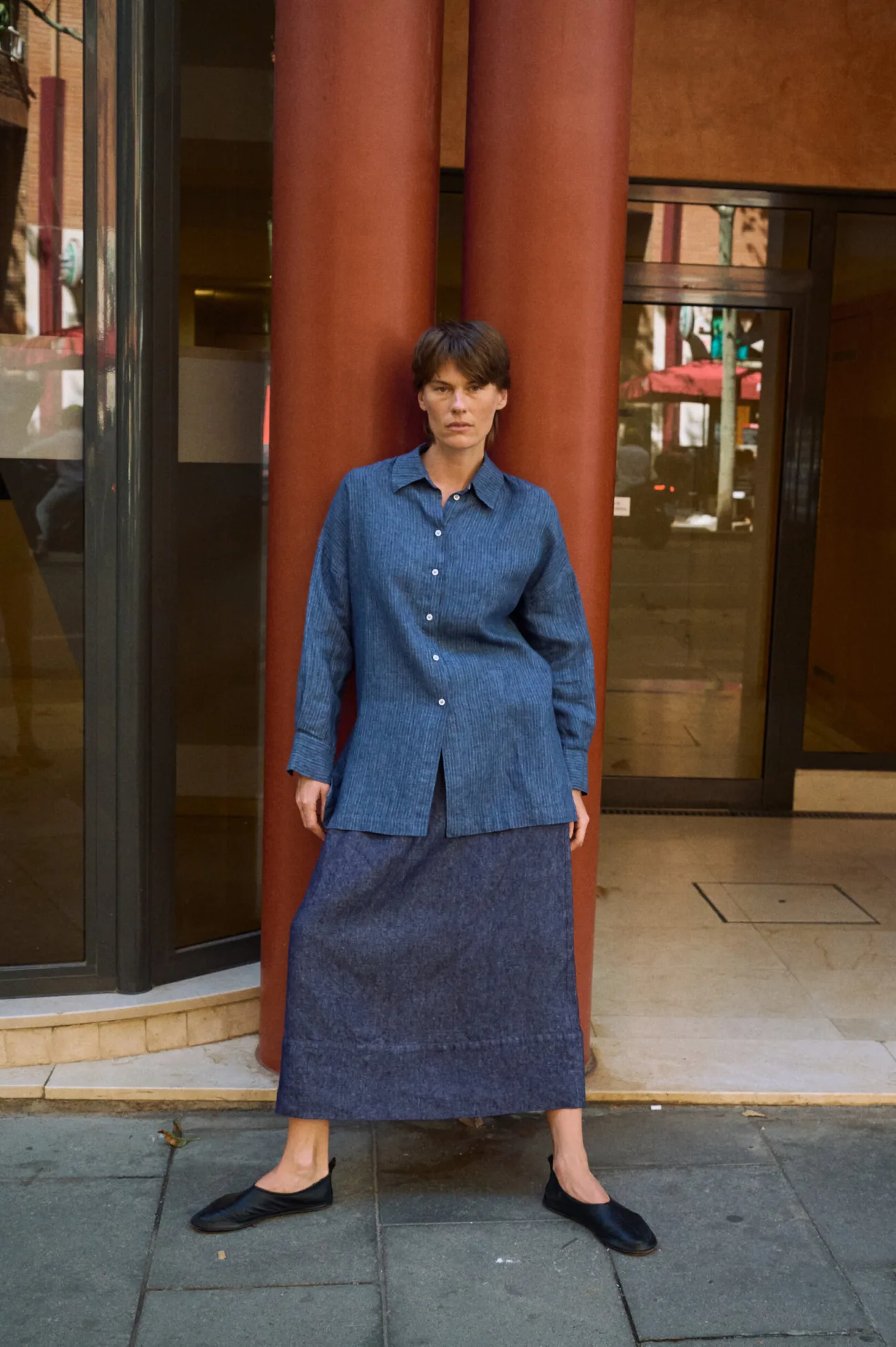 Denim linen maxi skirt with a subtle A-line silhouette, styled with a blue striped linen button-up shirt