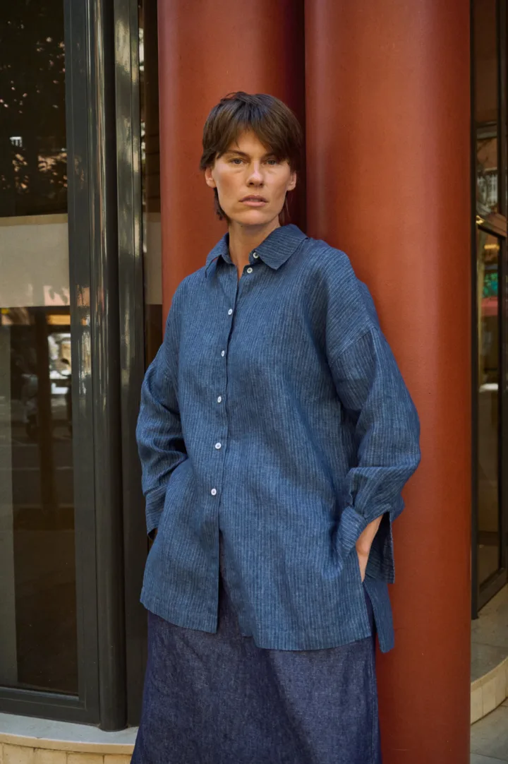 Blue striped linen button-up shirt with a relaxed oversized fit, pointed collar and side slits