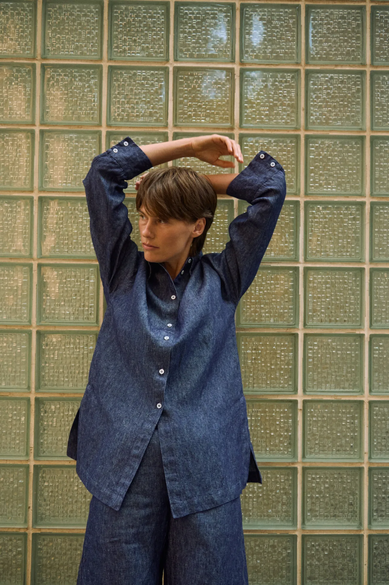 Blue denim linen shirt with button-down front, side slits, and buttoned cuffs