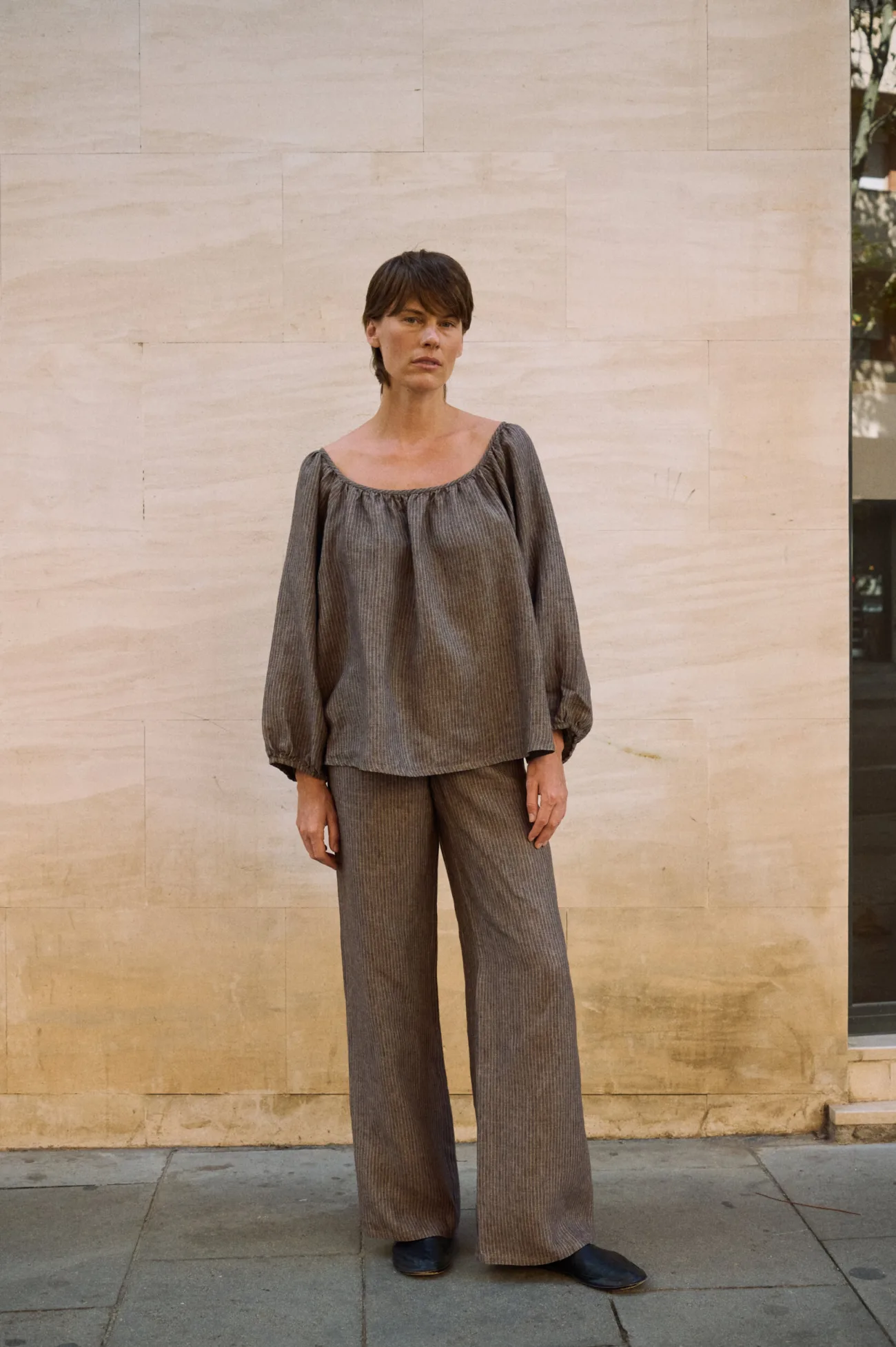 Brown striped linen wide-leg trousers styled with a matching loose linen blouse