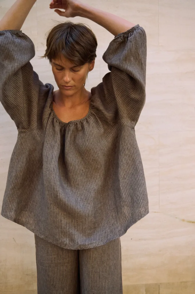 Close-up of a brown striped linen blouse with a softly gathered neckline and loose voluminous sleeves