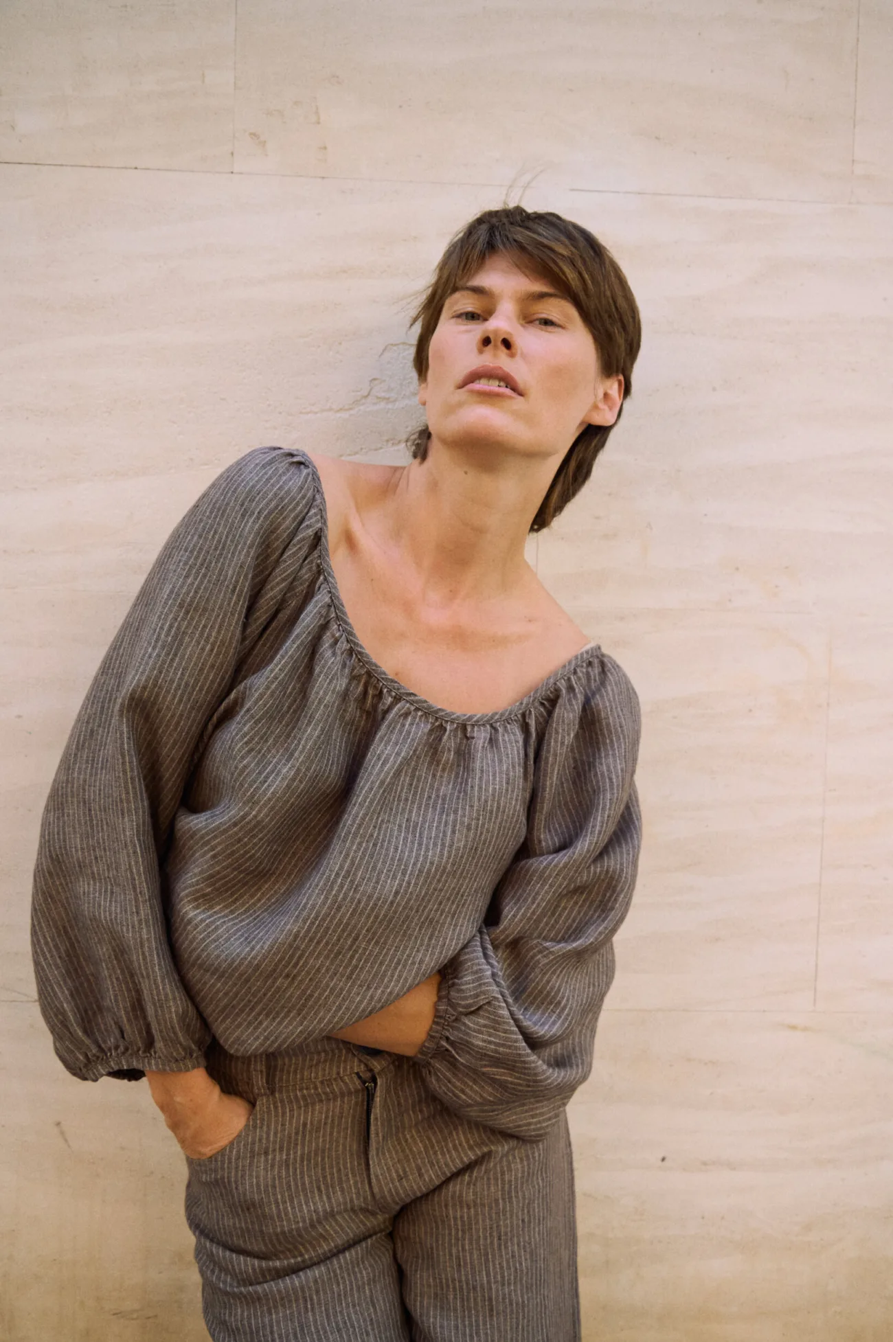 Brown striped linen blouse with a wide scoop neckline and billowy sleeves, styled with matching striped trousers